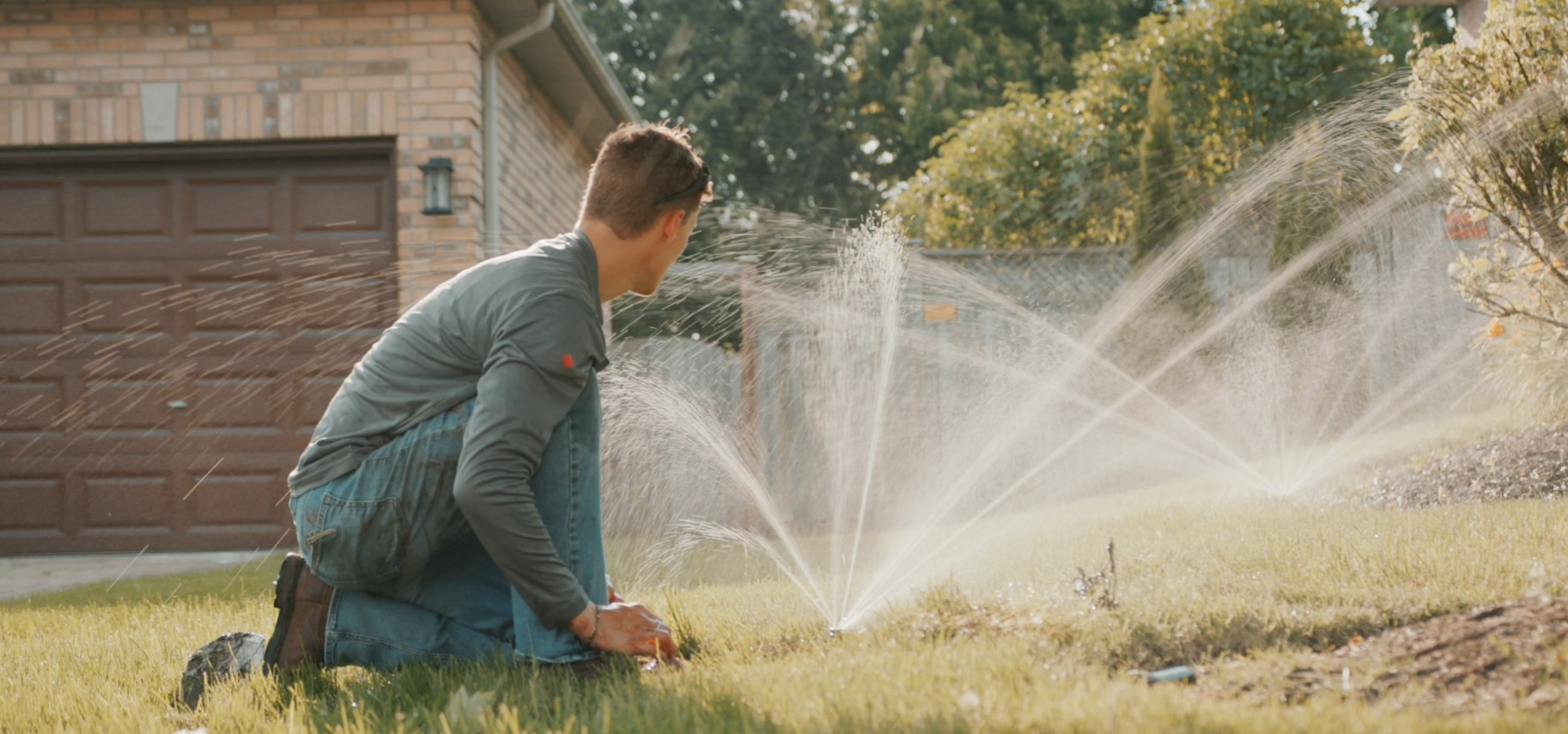 Certified Irrigation Technician completing testing and adjustments on sprinkler heads